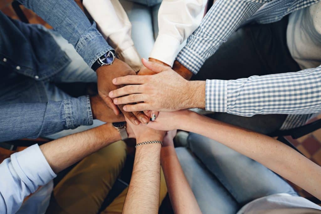 Top view of diverse people hands holding together in circle, hands stack